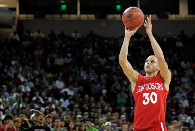 Steph Curry en acción para Davidson College, destacándose en el baloncesto universitario.