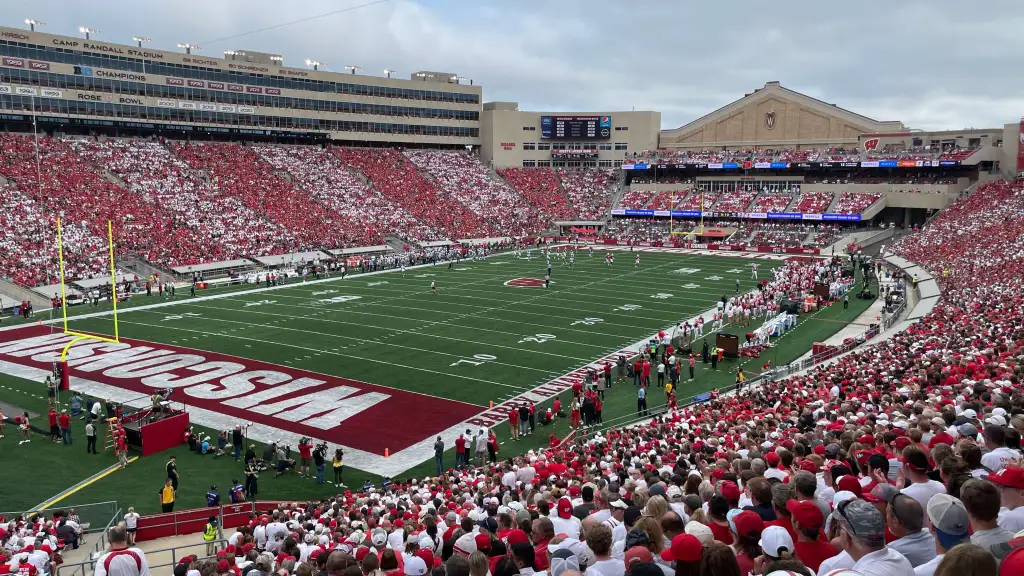 Vista dagli spalti dello vibrante e affollato stadio universitario del Wisconsin durante una partita emozionante, con i tifosi che incitano la loro squadra.