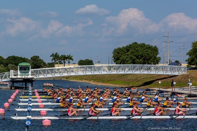 Rowing boats lined up for the start of a college rowing race.