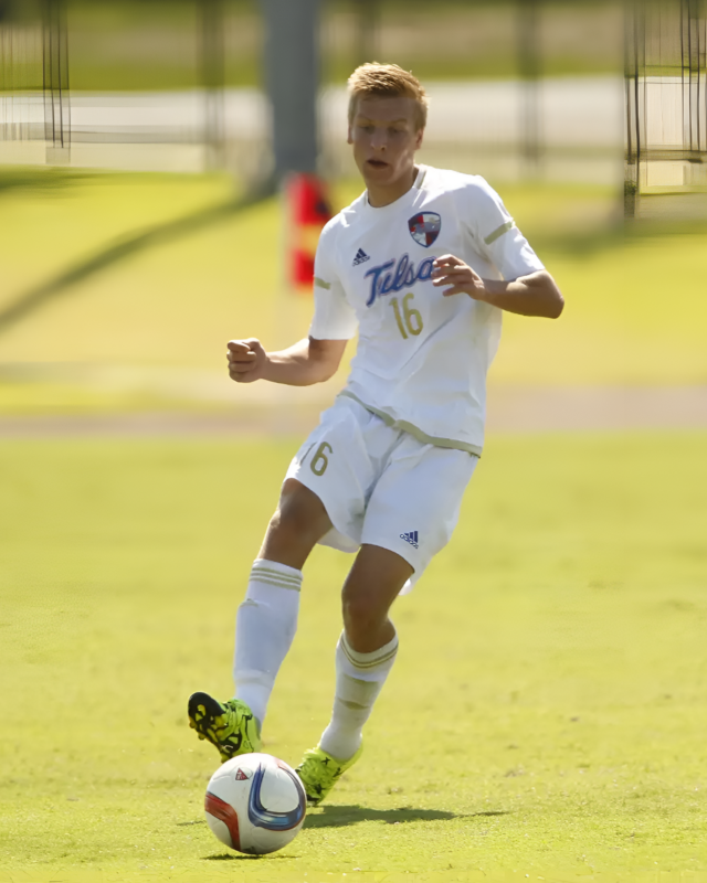 Kay Duit em ação durante um jogo de futebol, jogando pela University of Tulsa, dinâmico e focado na bola