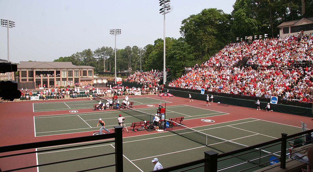 Complesso di tennis della Georgia con tribune affollate durante una partita universitaria.