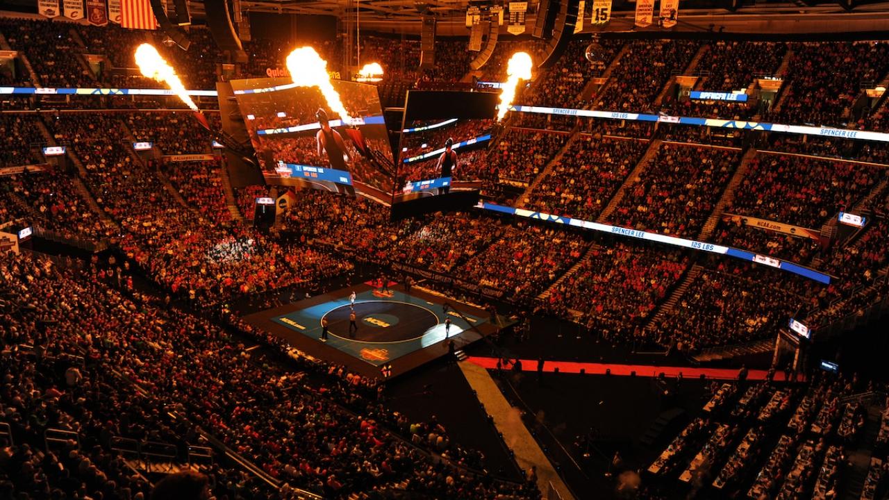 Aerial view of a packed stadium at a college wrestling match.